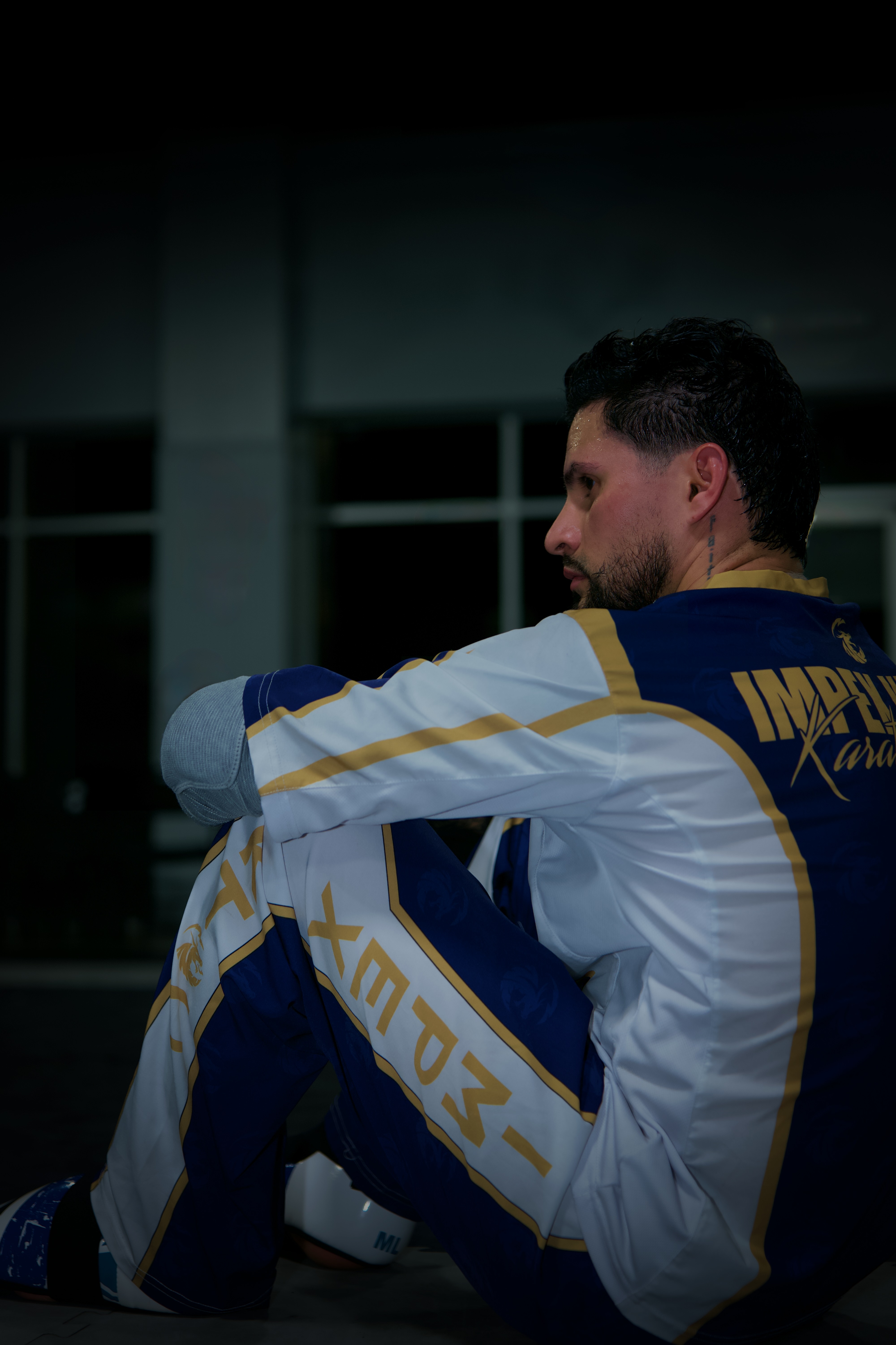 Retrato de una persona sentada con uniforme azul y blanco